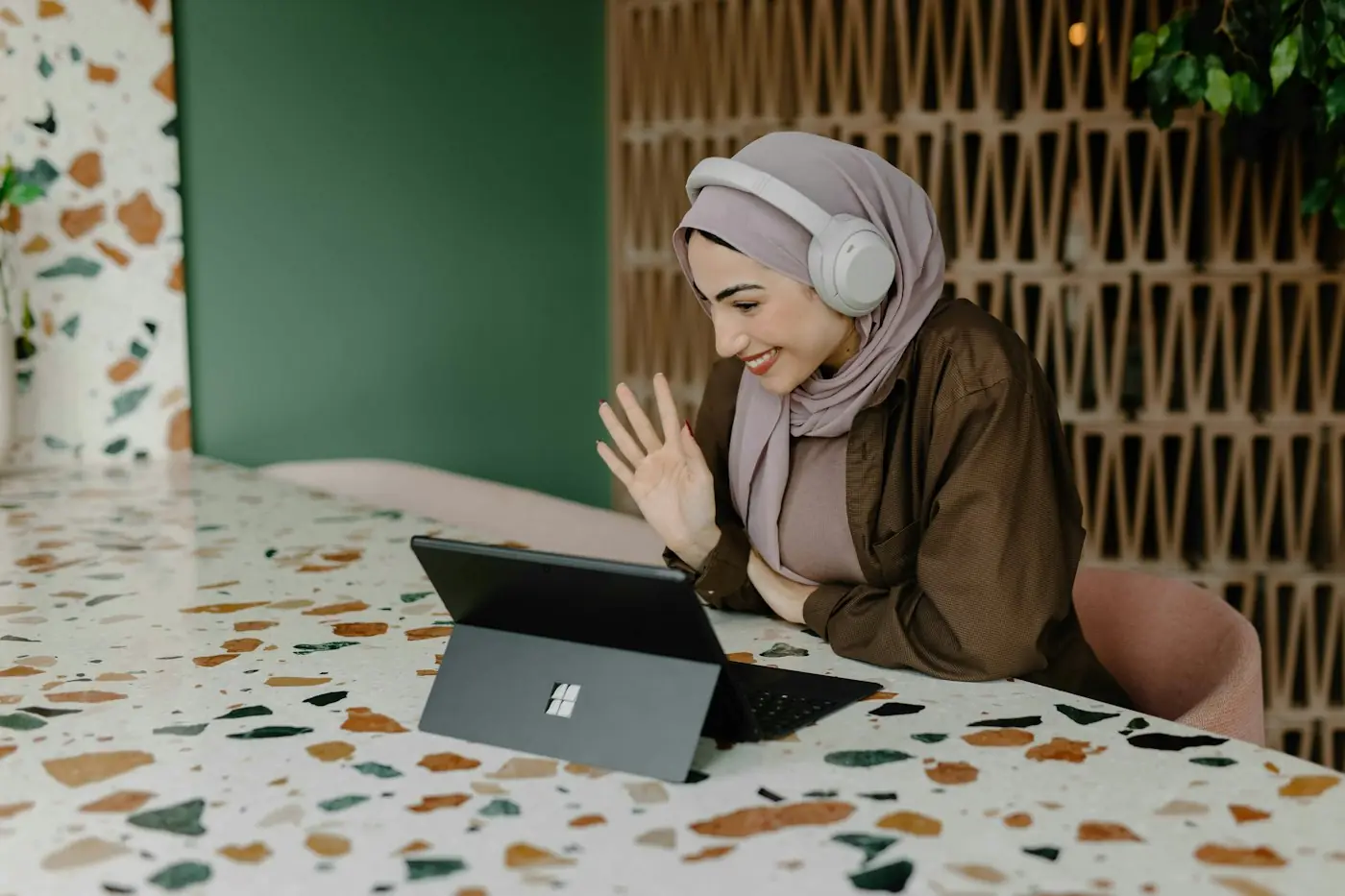 Hero Remote Remote professional in headphones joining a video call from her desk