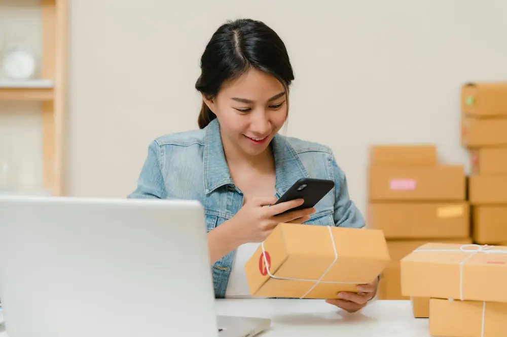 Ind Ecom Ecommerce owner checking an order next to packed boxes