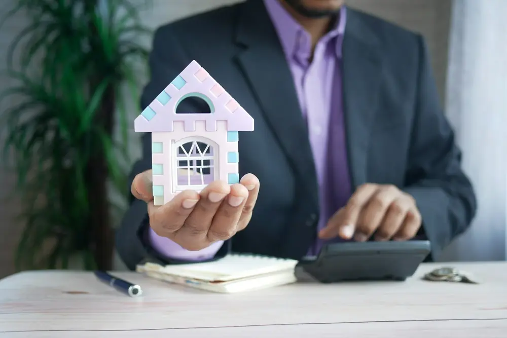 Ind Realestate Real estate professional holding a model house