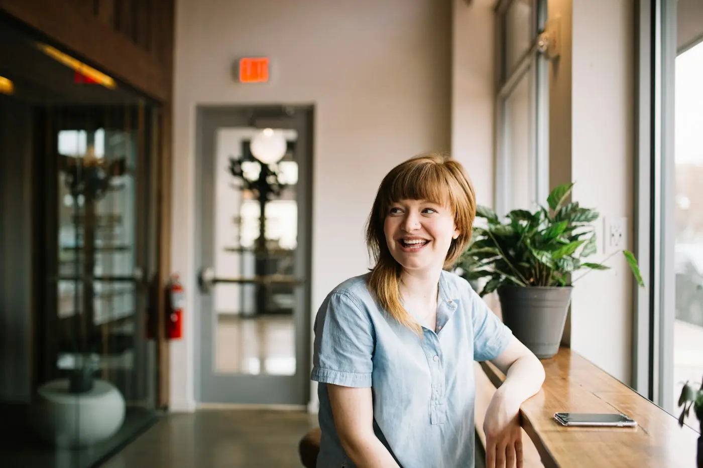 Professional smiling while working at her laptop by the window