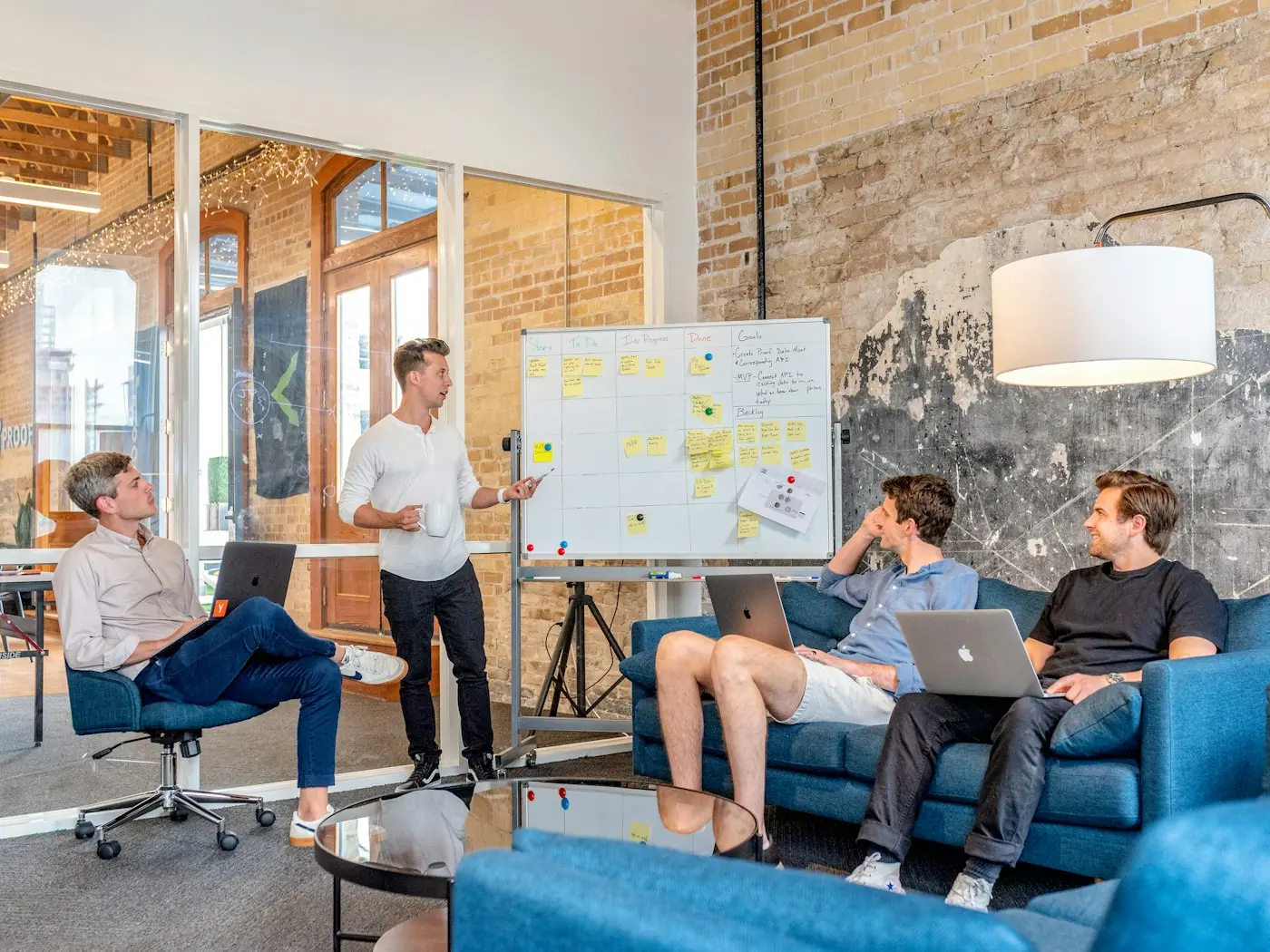 Services Hero Team meeting around a whiteboard with laptops open